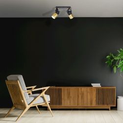 Czarny salon z drewnianą komodą, drewnianym fotelem i czarną lampą sufitową