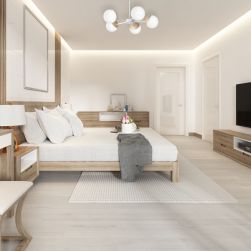 Przestronna sypialnia utrzymana w jasnych kolorach z dużym, białym łóżkiem, drewnianymi meblami, dywanem oraz żyrandolem Sfera wood 5xE14 Milagro