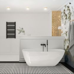 Elegancka łazienka wyłożona dekoracyjnymi płytkami, z białą wanną wolnostojącą Molis z czarną baterią ścienną, dwoma szarymi ręcznikami na ścianie i kinkietem