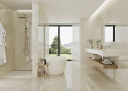 Duża łazienka wyłożona beżowymi płytkami imitującymi kamień w połysku Mervedere Crema Pulido, z wanną wolnostojącą, kabiną prysznicową, wiszącym blatem z umywalką i dwoma lustrami