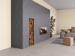 Salon ze ścianami wyłożonymi beżowymi płytkami 3D Moves Sand z kominkiem oraz kanapą i dywanem