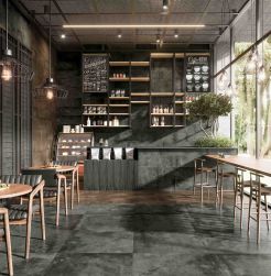 Restauracja, stoliki i krzesła dla gości, bar, na podłodze szare płytki, bar wyłożony Aparici Mud Anthracite Natural 24,9x100 płytka imitująca beton