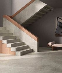 Korytarz ze schodami wyłożony płytkami lastryko Neo Granito Cashemere, z sofą i obrazem