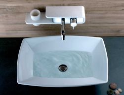 Widok na białą umywalkę napełnioną wodą z baterią umywalkową ścienną Paini Pad
