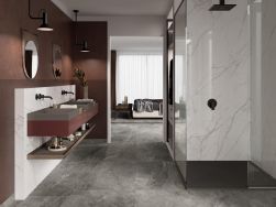 Łazienka ze ścianą pod prysznicem i za umywalką wyłożoną płytkami imitującymi marmur Lincoln White