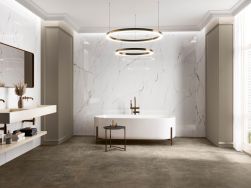 Jasna łazienka z podłogą wyłożoną płytkami imitującymi beton z kolekcji Argile oraz marmurowymi ścianami, z białą wanną wolnostojącą i baterią, lampą wiszącą, półką wiszącą z dwiema umywalkami i lustrem