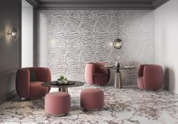 Pomieszczenie ze ścianą wyłożoną dekoracyjnymi płytkami z kolekcji Golden Zebra z dwoma okrągłymi stolikami oraz różowymi fotelami i pufami