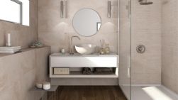 Kremowa łazienka z kabiną prysznicową, białą podwójną półką wiszącą, umywalką nablatową, okrągłym lustrem, akcesoriami łazienkowymi i płytkami drewnopodobnymi At.Rainier Nogal 20x120