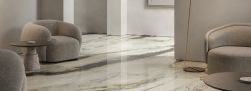 Salon z podłogą wyłożoną płytkami imitującymi marmur Marmi Maxfine Panda White, z beżowymi fotelami i stolikiem