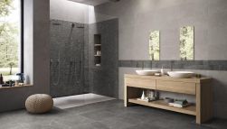 Ciemna łazienka z podłogą wyłożoną czarnymi płytkami imitującymi kamień Groove Mistique Black z podwójną kabiną prysznicową, drewnianą szafką z dwiema białymi umywalkami nablatowymi, dwoma lustrami i oknem