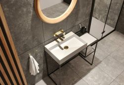 Fragment łazienki z białą umywalką nablatową Deante Correo na konsoli ze złotą baterią podtynkową i okrągłym lustrem