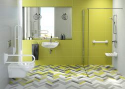 żółte płytki na ścianie, kolorowa podloga, duże lustro, kabina prysznicowa po prawej w rogu, chromowane baterie, biały zestaw wc podtynkowy Vital