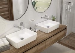 Łazienka z drewnianą szafką wiszącą z dwiema białymi umywalkami nablatowymi z korkami klik-klak okrągłymi w chromie, dwoma okrągłymi lustrami i kabiną prysznicową