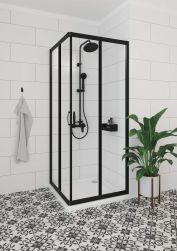 biała łazienka z czarno białymi płytkami na podłodze, czarna matowa kabina prysznicowa z czarnym zestawem prysznicowym boro, biały ręcznik na czarnym haczyku, roślina dekoracyjna z boku