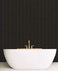 Ściana w łazience wyłożona czarną mozaiką Royal Chevron Black z białą wanną i złotą baterią