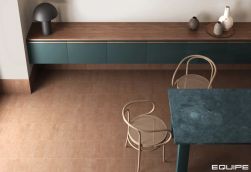 Pok&oacute;j z podłogą wyłożoną pomarańczowymi cegiełkami Stage Terracotta, ze stołem, dwoma krzesłami i wiszącymi szafkami