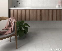 Łazienka wyłożona białymi cegiełkami Stage White z wiszącą p&oacute;łką z umywalką i fotelem
