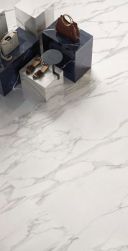 Zbliżenie na podłogę wyłożoną białymi płytkami imitującymi marmur z kolekcji Tele di Marmo w sklepie z ekspozycją butów i torebek