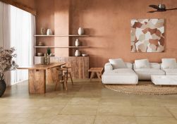 Salon w brązowych kolorach, biała kanapa, na podłodze płytki Terracota Siena Natural 59,2x59,2 płytka imitująca beton