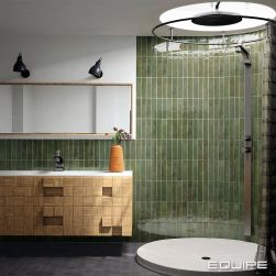 Łazienka z dużą, okrągłą kabiną prysznicową, wiszącą szafką z umywalką i szafką z lustrem, ciemną podłogą i zielonymi cegiełkami ściennymi z kolekcji Tribeca