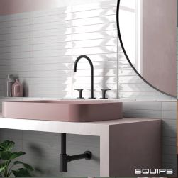 Ściana w łazience wyłożona jasnoszarymi cegiełkami dekoracyjnymi w połysku Vitral Axis Light Grey z różową umywalką nablatową