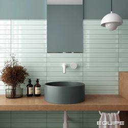 Ściana w łazience wyłożona miętowymi cegiełkami dekoracyjnymi w połysku Vitral Axis Mint, z drewnianym blatem, zieloną umywalką nablatową i lustrem