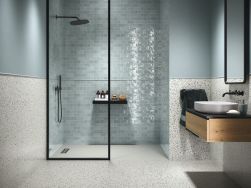 Łazienka wyłożona płytkami lastryko Epoca White Silken z kabiną prysznicową, wiszącą półką drewnianą z umywalką i lustrem w ramie