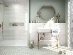 Łazienka z podłogą wyłożoną płytkami patchworkowymi Enya Acqua z kabiną prysznicową, umywalką na złotym stelażu i okragłym lustrem