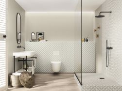 Łazienka wyłożona beżowymi płytkami patchworkowymi Enya Pumice z kabiną prysznicową, miską WC, umywalką na stelażu i owalnym lustrem
