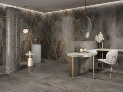 Łazienka ze ścianami wyłożonymi dekoracyjnymi płytkami imitującymi metal lappato Decor Ser AB Britannic Iron z prysznicem, umywalką stojącą, okrągłym lustrem, stołem i krzesłem