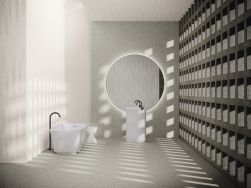 Łazienka wyłożona płytkami z kolekcji Esencia Material z białą wanną wolnostojącą oraz umywalką stojącą i dużym, okrągłym lustrem