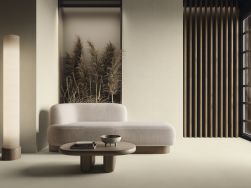 Minimalistyczny salon wyłożony beżowymi płytkami imitującymi beton Raw Toasted Smooth z niedużą kanapą i drewnianym stolikiem