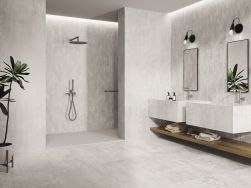 Łazienka wyłożona białymi płytkami imitującymi metal Odyssey Bianco z kabiną prysznicową, dwiema ściennymi umywalkami, dwoma lustrami i dwoma kinkietami