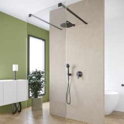 Łazienka z zieloną i białą ścianą, strefą prysznicową ze ścianką prysznicową Walk In z czarnymi mocowaniami i czarnym zestawem prysznicowym, białą szafką wiszącą z lampką i kwiatem w donicy