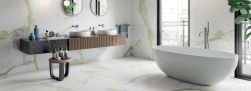 Elegancka łazienka wyłożona płytkami imitującymi marmur Marmi Maxfine White Calacatta, z wanną wolnostojącą, półką z dwiema umywalkami nablatowymi i dwoma okrągłymi lustrami