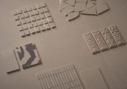 Pr&oacute;bki płytek ceramicznych z kolekcji NOK marki 41zero42, prezentujące r&oacute;żnorodne wzory i tekstury w beżowym kolorze o nazwie Taupe