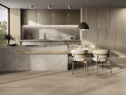 Nowoczesna kuchnia z szarymi meblami, kamieniem między szafkami i na wyspie i drewnopodobnej płytce dębowej