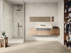 Łazienka w płytkach imitujących kamień w połączeniu z jasnym drewnem z płytek gresowych