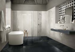 Łazienka z wanną wolnostojąca ciemną podłogą imitującą onyksowy marmur i bardzo jasnymi ścianami imitującymi marmur