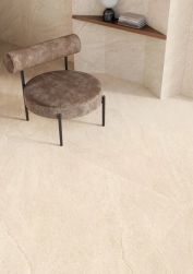 Nowoczesne płytki beżowe prostokątne na podłodze na tle małego fotelika brązowego