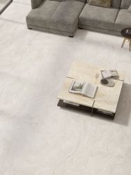 Nowoczesny salon: jasnobeżowa podłoga Provenza Unique Travertine, szara modułowa sofa i kwadratowy stolik kawowy z kamiennym blatem i książkami.