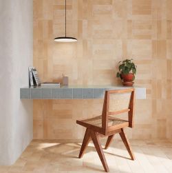 Nowoczesny kącik do pracy z terakotowymi płytkami na ścianie i podłodze biurkiem z niebiesko-szarymi kafelkami drewnianym krzesłem z plecionką i wiszącą czarną lampą.