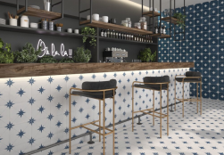 Wnętrze restauracji, bar z akcesoriami, przy barze czarne krzesła barowe, ściana wyłożona płytkami Ponent Blue 22,3x22,3, ścianka barowa i podłoga wyłożona płytkami Llevant Blue 22,3x22,3 płytki patchworkowe
