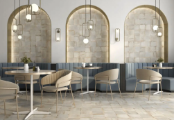 Wnętrze restauracji, stoliki z krzesłami, dekoracyjne lampy, na ścianie i na podłodze płytki Robin White 20,4x20,4
