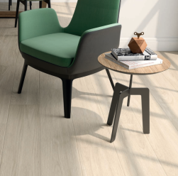 Wnętrze pokoju zielony fotel, stolik kawowy, na podłodze płytki Olea Haya 23x120 płytki drewnopodobne