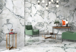 Salon, dwa zielone fotele, mały stolik kawowy, półka pod ścianą z dekoracjami, na ścianie i podłodze płytki Geotiles Oyster Blanco Polished Rect. 60x120 płytki imitujące kamień