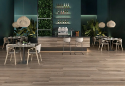 Restauracja, bar, stoliki z krzesłami, ściany w kolorze butelkowej zieleni, na podłodze płytki Geotiles Balmore Coffee Rect. 60x120 płytki drewnopodobne