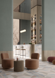 Restauracja, ściany w szarym kolorze, bar, przy barze krzesła barowe, stoliki z pufami, na podłodze płytki One 02 120x120 płytka dekoracyjna