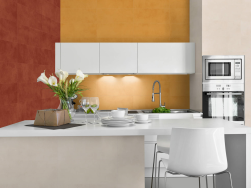 Kuchnia, białe meble, jedna ze ścian wyłożona płytkami w musztardowym kolorze, na drugiej ścianie Carpi Terra 20x50 płytka imitująca beton