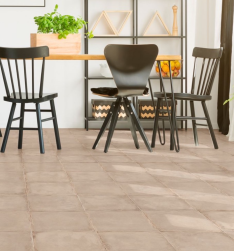Przy stole czarne krzesła, metalowa p&oacute;łka z dekoracjami, podłoga wyłożona płytkami Triana Beige 25x25 płytka bazowa